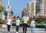 10月1日大队民警在迎宾路工人村交叉路口引导小朋友过马路。 - 安徽新闻网