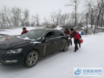 图为积雪深厚，道路打滑，桃园镇党员志愿者冒雪帮助车辆缓慢通过光明大道驼峰桥。 - 安徽新闻网