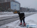 图为王奶奶在公交站马路旁铲雪 - 安徽新闻网