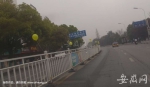 道路中间的隔离栏上挂了很多黄色气球。 - 安徽网络电视台