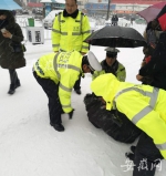 老人不慎摔倒 界首交警蹲雪地为其撑伞半小时 - 安徽网络电视台